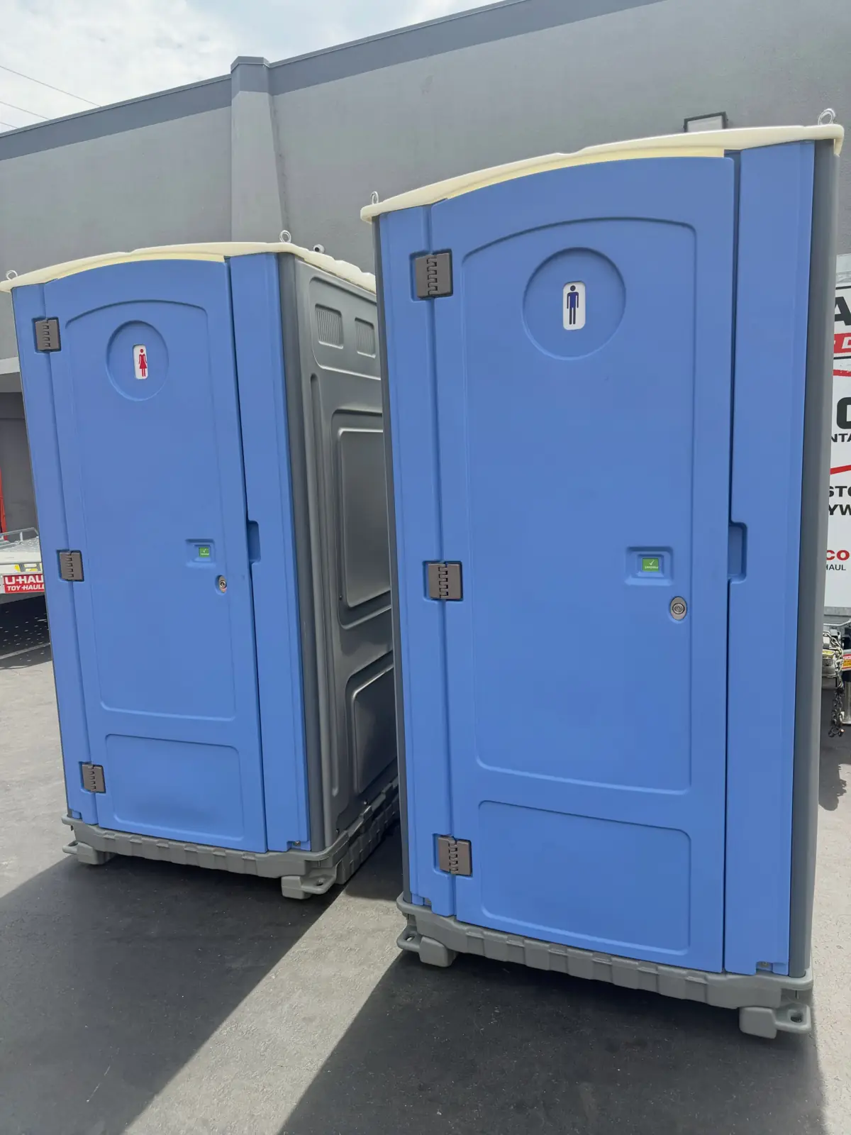 Two blue portable toilets ready for delivery